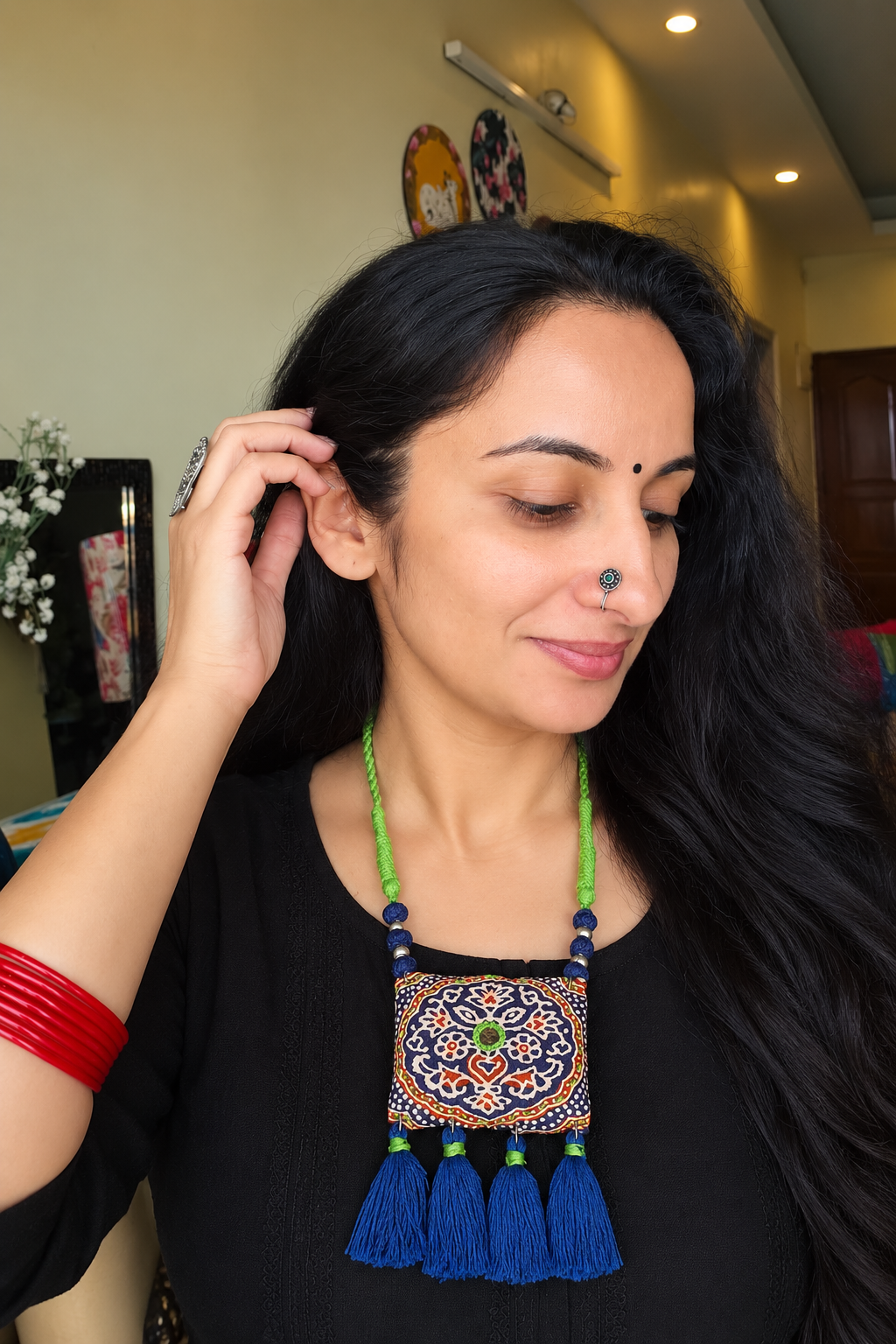 Woman wearing blue Kutchi fabric necklace with mirror work and tassels