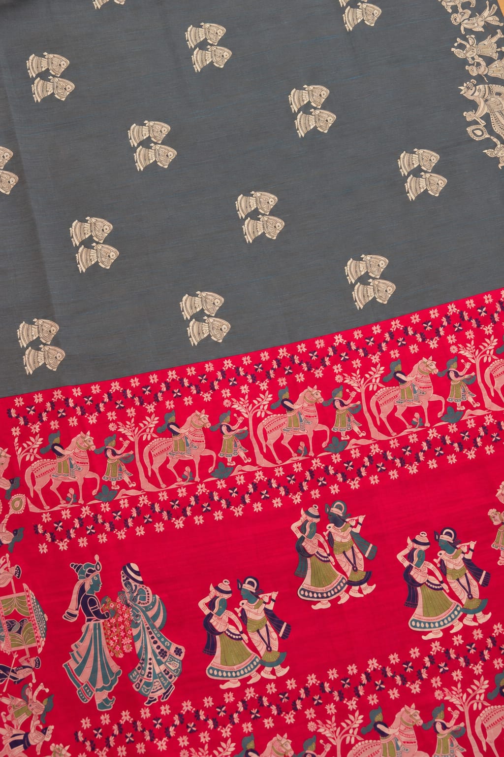 A close-up of a fabric or textile with a dark gray upper section featuring small beige motifs, and a wide red palla section with colorful traditional figures and decorative patterns.